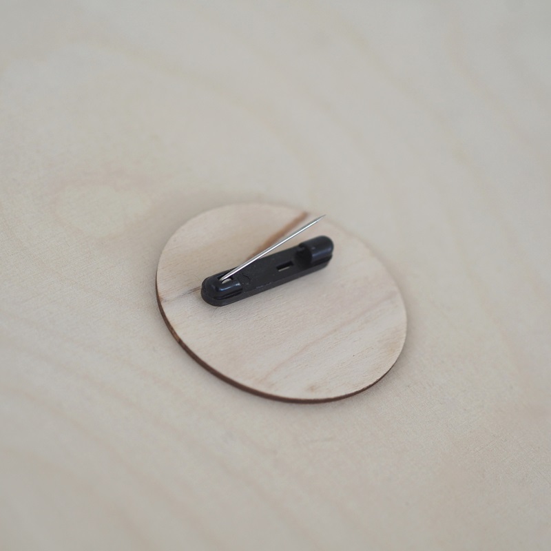 Puinen nimikyltti neulakiinnityksellä